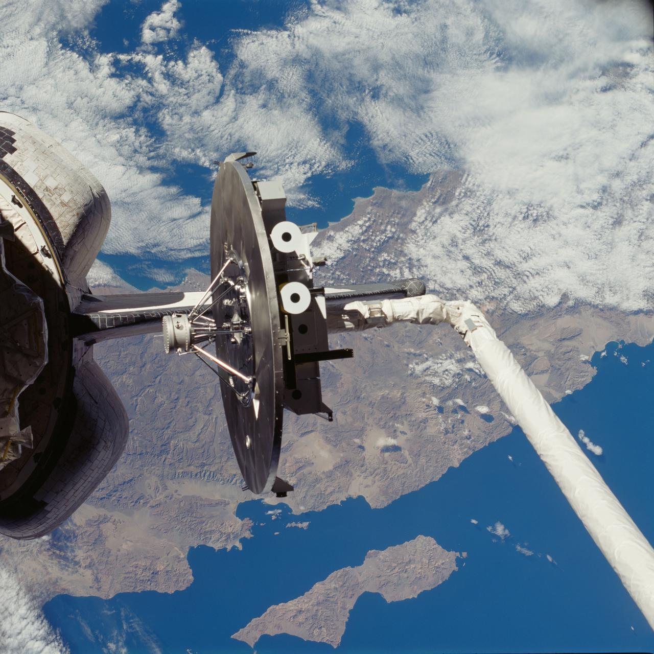 STS080-708-065 (19 Nov.-7 Dec. 1996) --- Backdropped against part of Baja California, the Wake Shield Facility (WSF) is about to be re-berthed in the cargo bay of the Earth-orbiting space shuttle Columbia.  Columbia's Remote Manipulator System (RMS) was used extensively during operations with the experiment.