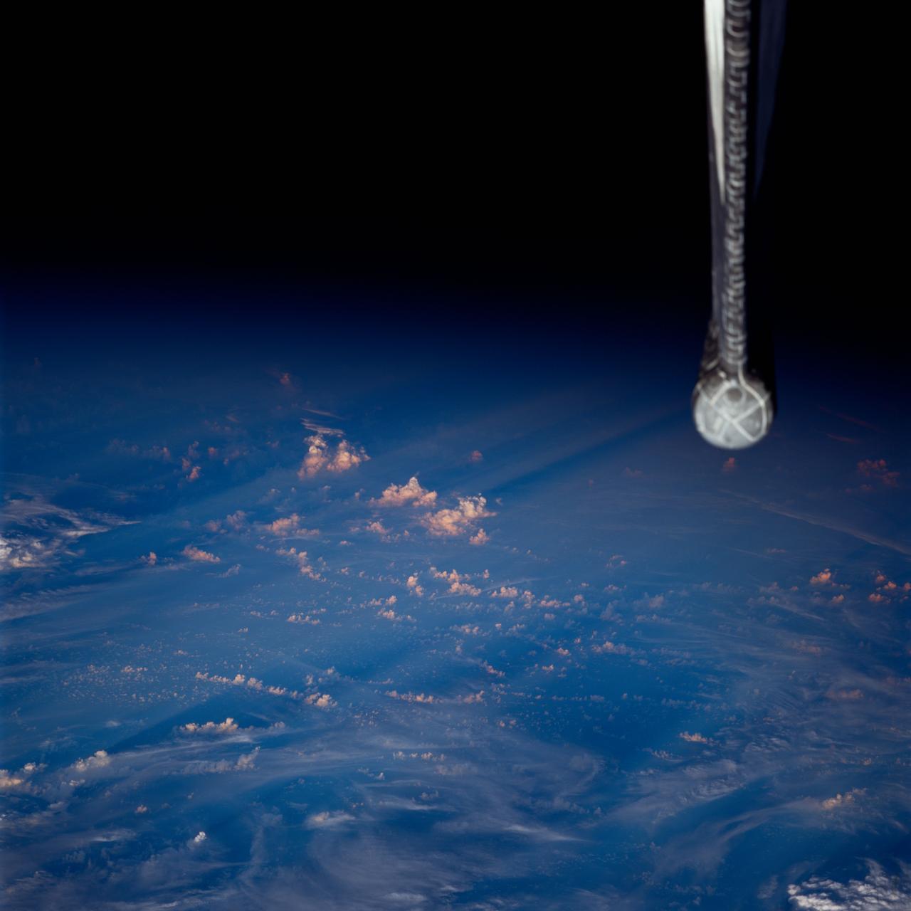 STS080-752-011 (19 Nov.-7 Dec. 1996) --- This view, photographed by one the crewmembers aboard the Earth-orbiting space shuttle Columbia, shows an area covered with clouds near the terminator thus the long shadows from the towering clouds. A portion of the vertical stabilizer of the space shuttle Columbia is seen on the right. Vortices indicate that it is a Southern Hemisphere photograph.