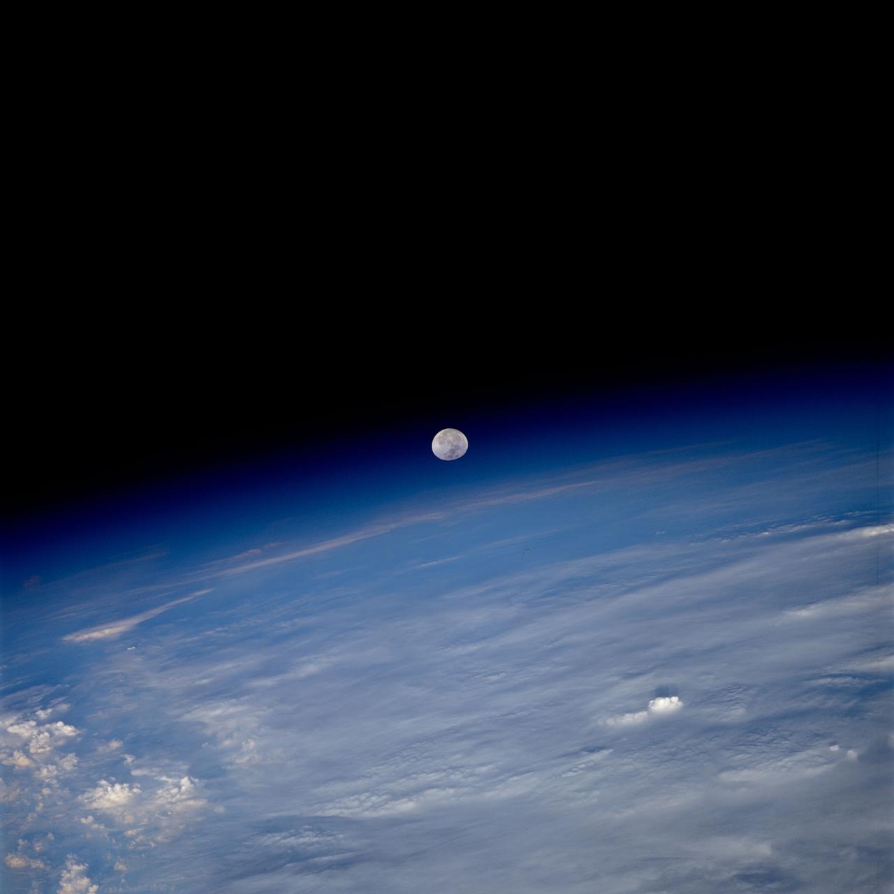 STS080-759-038 (19 Nov.-7 Dec. 1996) --- As photographed by the crewmembers aboard the space shuttle Columbia, a full moon is about to set beyond the limb of Earth.  A full moon should be round but when it is near the limb, or edge of Earth, the atmosphere tends to distort the shape.  The atmosphere, stratosphere, ionosphere is in reality acting as a lens, thus the distorted shape of the Moon.  As the Moon reaches the Earth's horizon it will become "eggshaped".