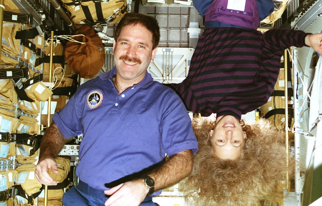 STS081-303-015 (12-22 Jan. 1997) --- Early in the part of the mission during which the Space Shuttle Atlantis was docked with Russia's Mir Space Station, impending duties appear to have Marsha S. Ivins topsy-turvy. Pictured in Spacehab's new Double Module (DM), astronauts Ivins and John M. Grunsfeld were involved with the transfer of supplies from Atlantis to Mir.