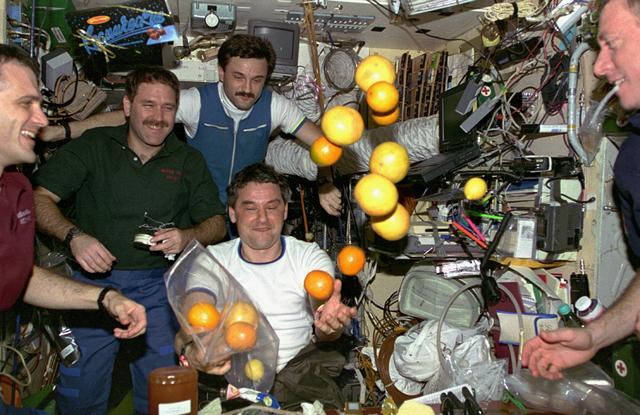 STS081-343-014 (12-22 Jan. 1997) --- Oranges and grapefruit brought up from Earth get a popular reception by the Mir-22 crewmembers.  Left to right astronauts Peter J. K. (Jeff) Wisoff and John M. Grunsfeld, along with cosmonauts Aleksandr Y. Kaleri and Valeri G. Korzun, Mir-22 flight engineer and commander respectively, view the microgravity behavior of the seasonal gifts. Astronaut Michael A. Baker, mission commander, looks on at frame's right edge.