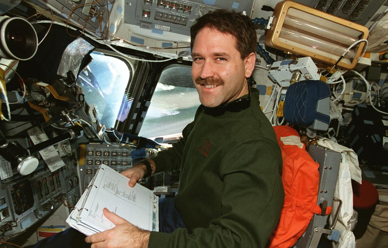STS081-368-018 (12-22 Jan. 1997) --- Astronaut John M. Grunsfeld, STS-81 mission specialist, mans the pilot's station on the Space Shuttle Atlantis' flight deck during rendezvous operations with Russia's Mir Space Station.