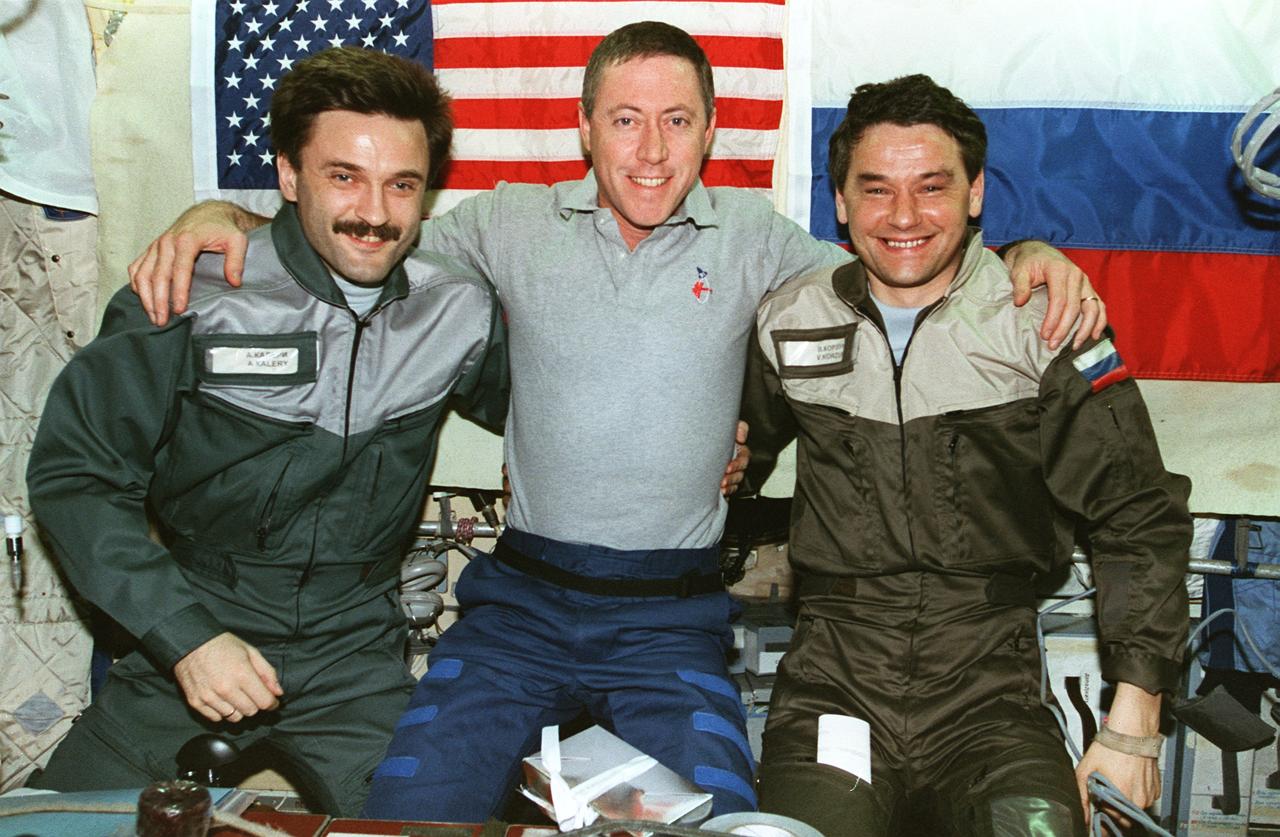 STS081-369-028 (12-22 Jan. 1997) --- On the eve of undocking of the Space Shuttle Atlantis and Russia's Mir Space Station, astronaut Michael A. Baker (center), STS-81 mission commander, bids farewell to cosmonauts Aleksandr Y. Kaleri (left), Mir-22 flight engineer, and Valeri G. Korzun, Mir-22 mission commander. The three are in the Base Block Module of the Mir complex.