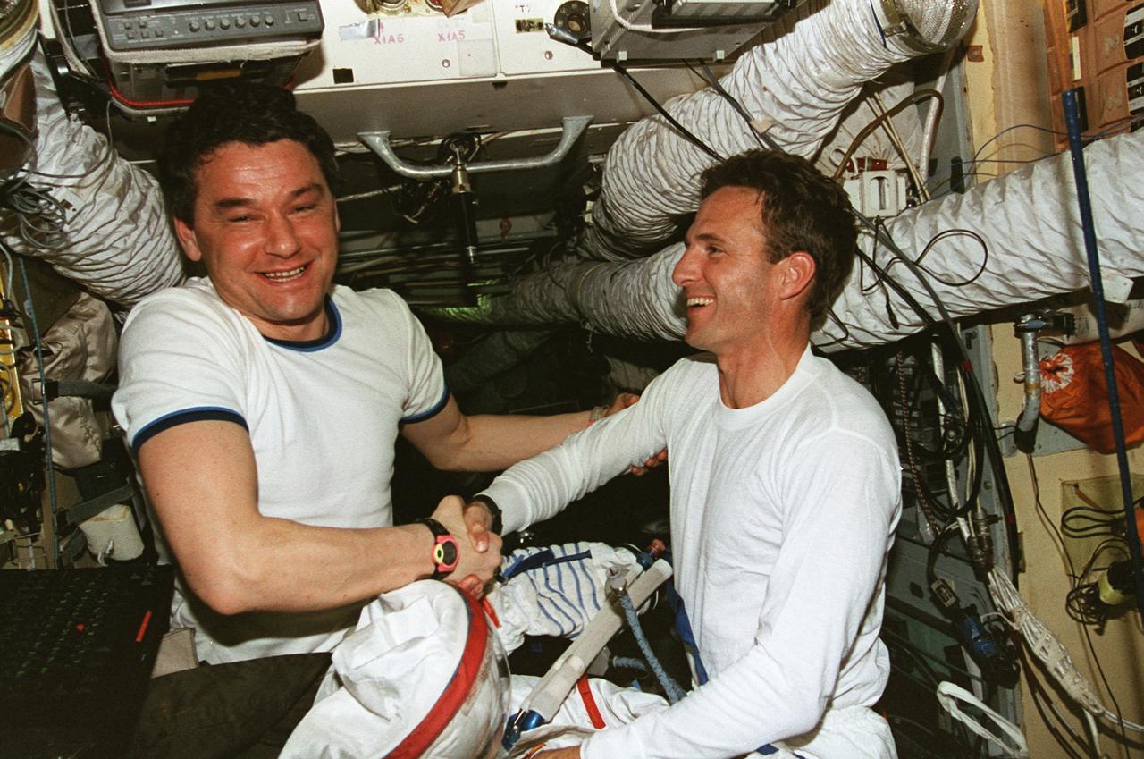 STS081-372-018 (12-22 Jan. 1997) --- One of his first acts as cosmonaut guest researcher for Mir-22 sees Jerry M. Linenger (right) check out his orlan space suit on Russia's Mir Space Station Base Block Module.  Cosmonaut Valeri G. Korzun, Mir-22 mission commander, and the second of four commanders Linenger will be sharing in-space time aboard the Space Shuttle Atlantis and Mir, congratulates the recent addition to the crew.