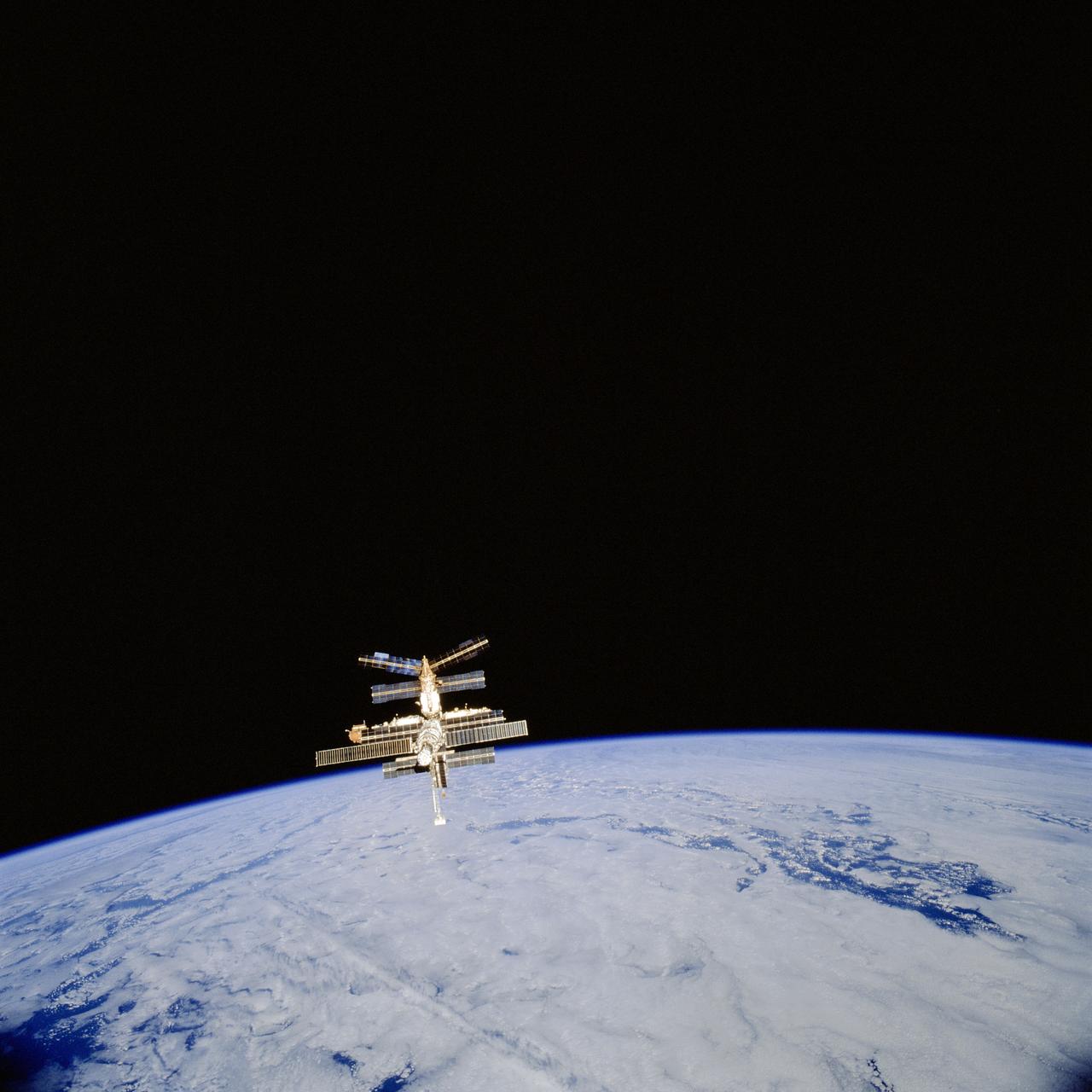 STS081-701-012 (20 Jan 1997) --- Following the separation of the Space Shuttle Atlantis and Russia?s Mir Space Station is backdropped against a cloud-draped Earth in this 70mm frame.  Following five days of joint activities between the American and Russian crews, the two spacecraft separated on January 20, 1997.