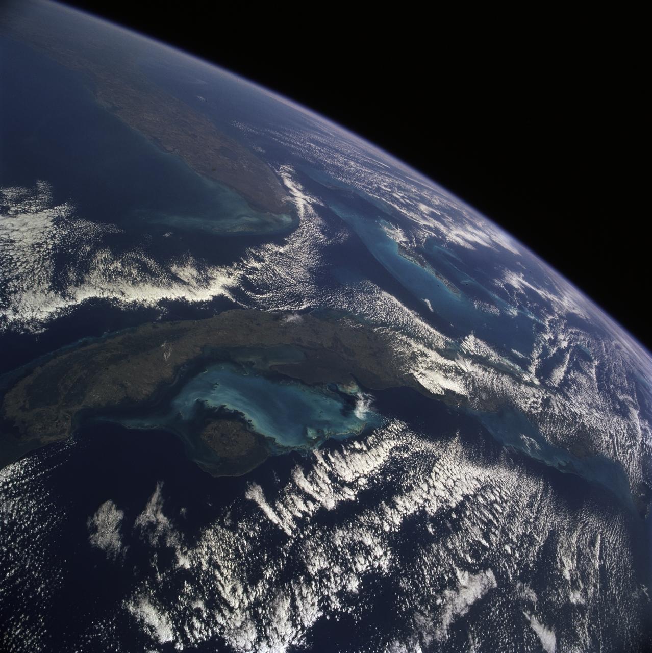 STS081-711-009 (12-22 Jan. 1997) --- As photographed with a 70mm handheld camera from the Earth-orbiting Space Shuttle Atlantis, this image provides a northeastward panorama of the Florida peninsula, the northern Bahamas and Cuba as well as a synoptic view of the northern Caribbean region. Lake Okeechobee and the urban region around Miami are the two key visual points in Florida. The turquoise shallow water platforms around the Florida Keys, the Bahamas, and south of Cuba contrast with the deep blue color of the deeper channels which separate Florida from Cuba and the Bahamas. Offshore breezes keep the coastal areas clear of clouds.
