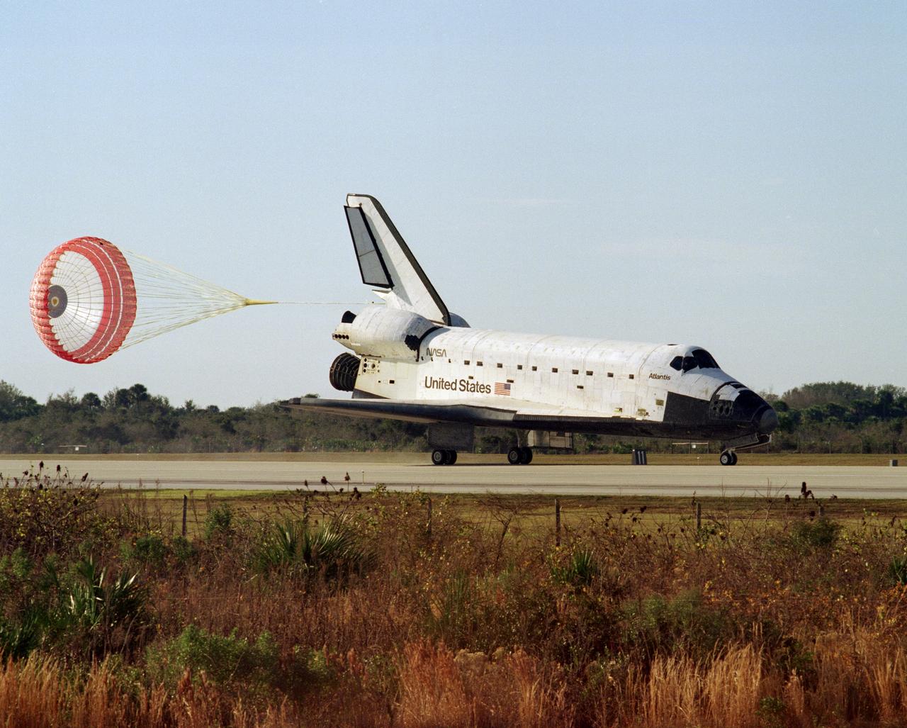 STS081-S-010 (22 Jan. 1997) --- A drag chute is deployed as the Space Shuttle Atlantis rolls toward a wheels stopped mode on Runway 33 at the Kennedy Space Center (KSC) to conclude the fifth Shuttle-Mir docking mission.  Coming to a halt at 9:22:44 a.m. (EST), January 22, the mission also accomplished the return of astronaut John E. Blaha, cosmonaut guest researcher, who had been aboard Russia's Mir Space Station complex since mid September 1996.  Blaha was replaced by Jerry M. Linenger during the five days of joint activities of the Mir-22 and STS-81 crew members while Atlantis and Mir were docked in Earth-orbit.  At main gear touchdown, the mission's duration was 10 days, 4 hours and 55 minutes.  This was the 34th space shuttle landing at KSC.  The crew aboard at landing included astronauts Michael A. Baker, commander; Brent W. Jett, Jr., pilot; Blaha; and mission specialists Marsha S. Ivins, Peter J. K. (Jeff) Wisoff and John M. Grunsfeld.