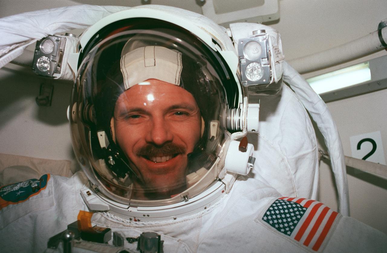 STS082-344-018 (11-21 Feb. 1997) --- Attired in the Extravehicular Mobility Unit (EMU) space suit, astronaut Steven L. Smith, mission specialist, is in the airlock of Discovery preparing for one of five STS-82 spacewalks. The sessions of extravehicular activity (EVA), of which Smith eventually participated in three, were conducted in order to service the Hubble Space Telescope (HST), temporarily latched in Discovery's payload bay.