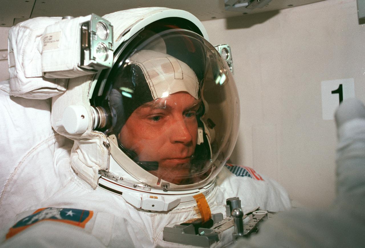 STS082-344-019 (11-21 Feb. 1997) --- Attired in the Extravehicular Mobility Unit (EMU) spacesuit, astronaut Mark C. Lee, payload commander, is in the airlock Discovery preparing for one of five STS-82 space walks. The sessions of extravehicular activity (EVA), of which Lee eventually participated in three, were conducted in order to service the Hubble Space Telescope (HST), temporarily latched in Discovery's payload bay.