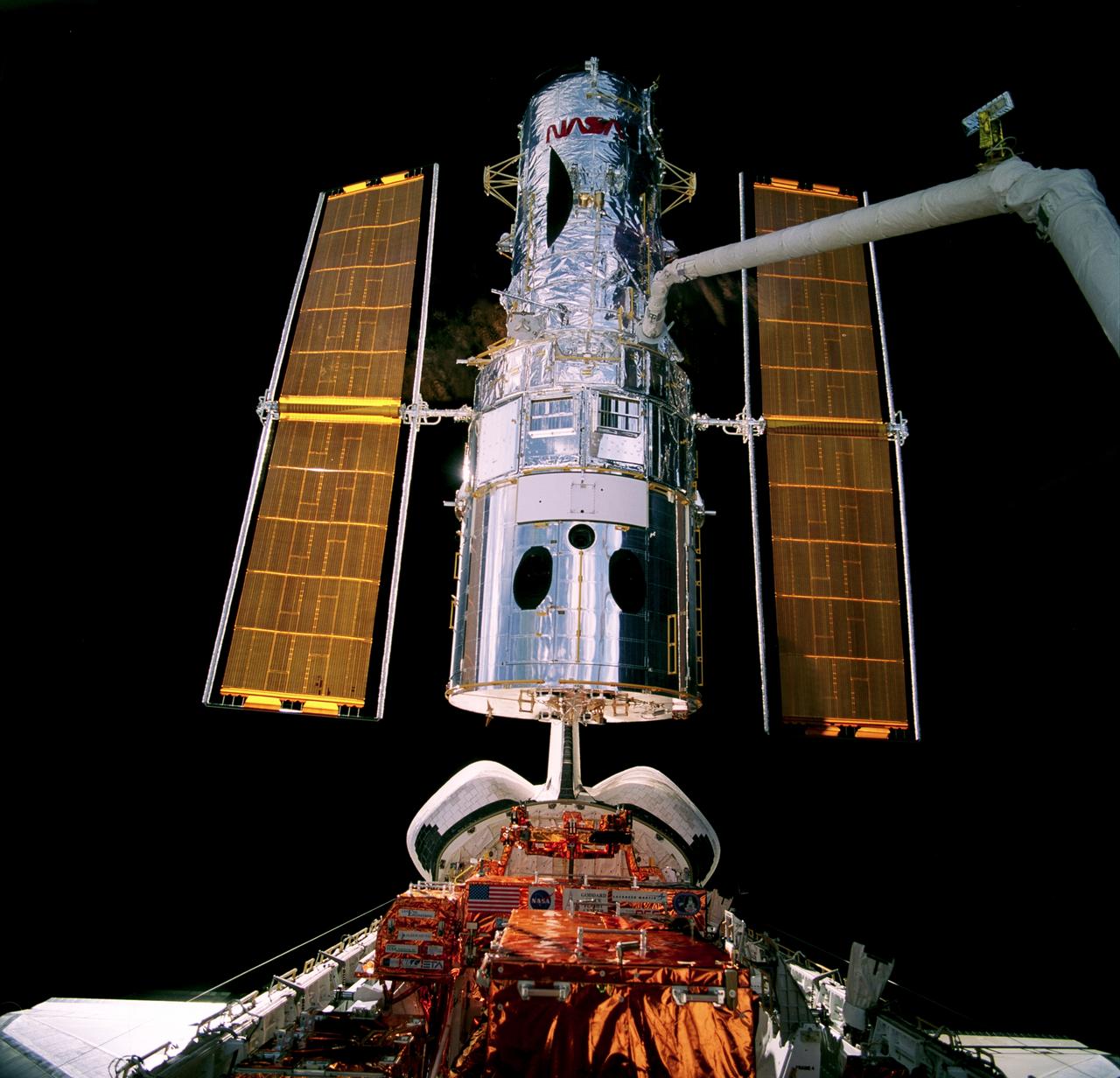 STS082-709-097 (18 Feb. 1997) --- Backdropped against the darkness of space, the Hubble Space Telescope (HST) is lifted by the Remote Manipulator System (RMS) from its berth in the cargo bay of the Earth-orbiting Space Shuttle Discovery following its servicing by the astronauts and just prior to its release back into space. Two teams of space walkers alternated Extravehicular Activity (EVA) days to complete five total days of servicing chores on the orbiting HST observatory.