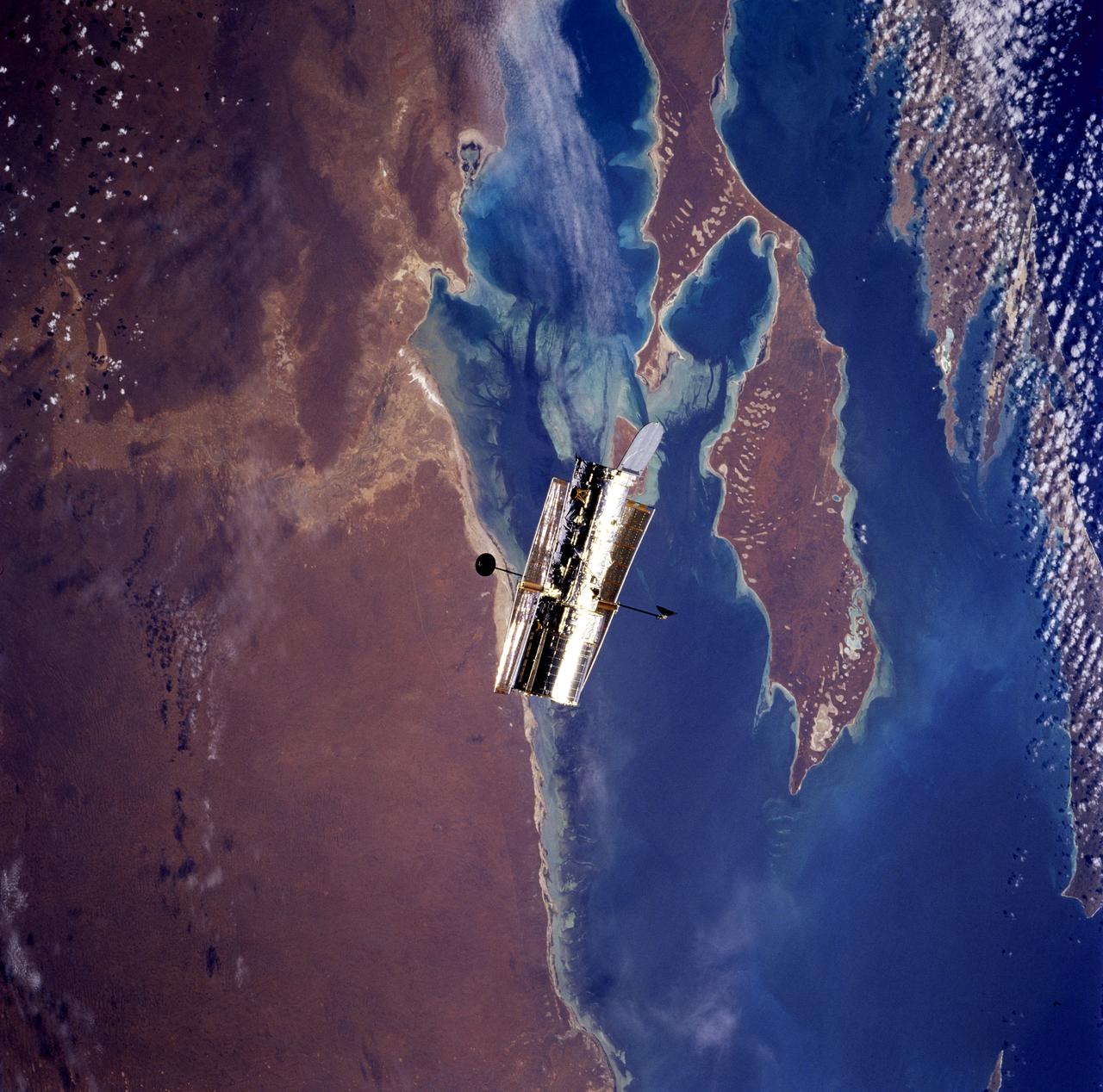 STS082-746-071 (11-21 Feb. 1997) --- This nearly-vertical view, photographed from the Space Shuttle Discovery, shows the Hubble Space Telescope (HST) over Shark Bay. Shallowest parts of the bay appear light blue. In this view of Australia's arid west, sets of sand dunes are clearly visible on Peron Peninsula (lower center) from southwest to northeast (bottom left to top right), blown by the prevailing wind. Hartog Island lies bottom right.