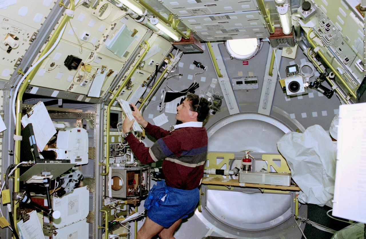 STS083-302-002 (4-8 April 1997) --- At the MidDeck Glove Box (MGBX), astronaut Donald A. Thomas, mission specialist, prepares to conduct the Internal Flows in Free Drops (IFFD) experiment.  The IFFD is meant to study drops of several liquids, including water, water/glycerin and silicon oil.  Flows within the drops and shape and stability are studied under varying acoustic pressure.  The MGBX is the overall facility that holds experiments on materials that are not approved for study in the open Spacelab environment.
