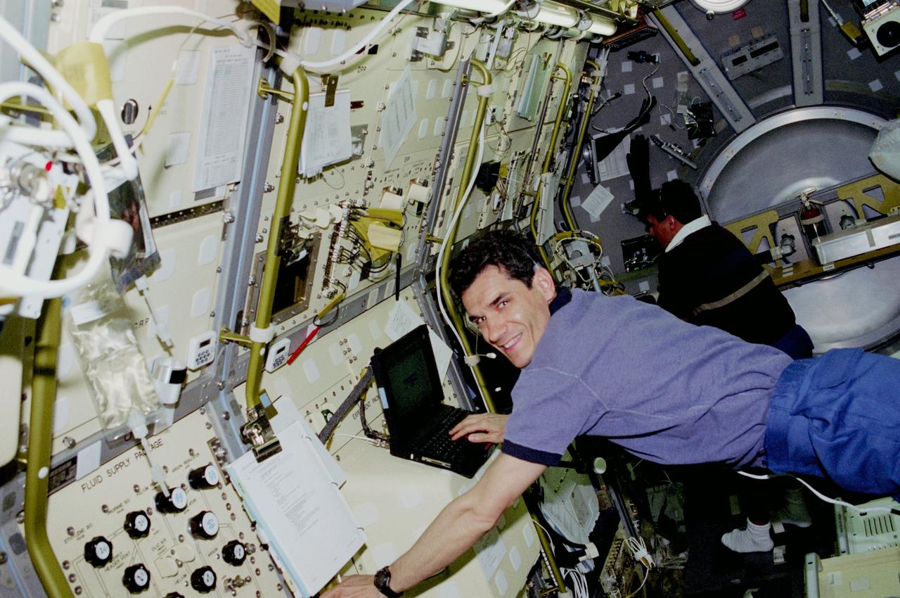 STS083-302-005 (4-8 April 1997) --- Payload specialist Gregory T. Linteris enters data on the progress of a Microgravity Sciences Laboratory (MSL-1) experiment on a lap top computer aboard the Spacelab Science Module while astronaut Donald A. Thomas, mission specialist, checks an experiment in the background.  Linteris and Thomas, along with four other NASA astronauts and a second payload specialist supporting the Microgravity Sciences Laboratory (MSL-1) mission were less than a fourth of the way through a scheduled 16-day flight when a power problem cut short their planned stay.