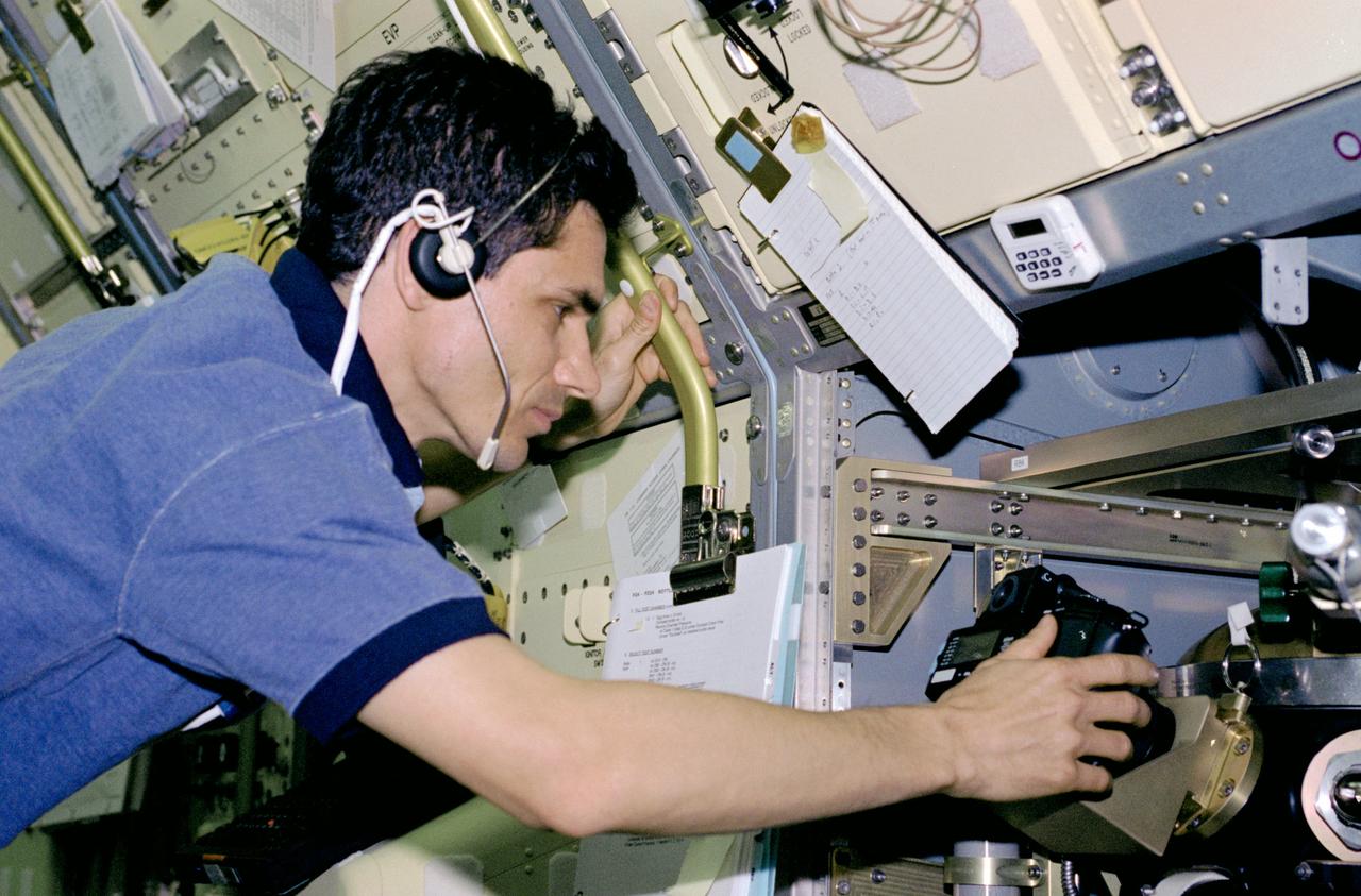 STS083-312-017 (4-8 April 1997) --- Payload specialist Gregory T. Linteris sets up a 35mm camera, one of three photographic/recording systems on the Drop Combustion Experiment (DCE) Apparatus.  DCE is an enclosed chamber in which Helium-Oxygen fuel mixtures are injected and burned as single droplets.  Combustion of fuel droplets is an important part of many operations, home heating, power production by gas turbines and combustion of gasoline in an automobile engine.