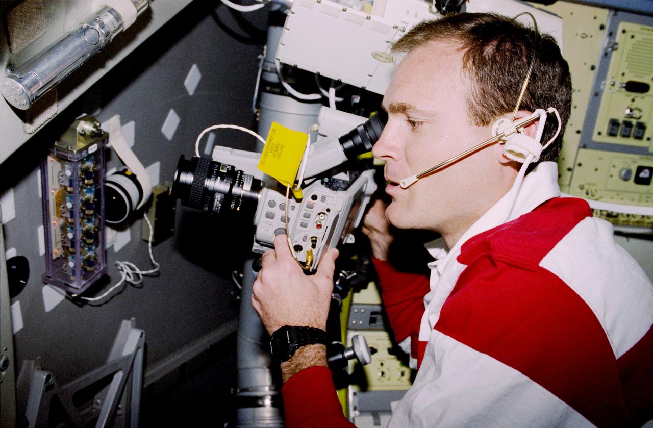 STS083-313-012 (4-8 April 1997) --- Astronaut James D. Halsell, Jr., mission commander, uses a Hi-8mm camcorder to videotape the Hand Held Diffusion Test Cells (HHDTC), in the Spacelab Module aboard the Earth-orbiting Space Shuttle Columbia. Each test cell has three chambers containing a protein solution, a buffer solution and a precipitant solution chamber. Using the liquid-liquid diffusion method, the different fluids are brought into contact but not mixed. Over a period of time, the fluids will diffuse into each other through the random motion of molecules. The gradual increase in concentration of the precipitant within the protein solution causes the proteins to crystallize.