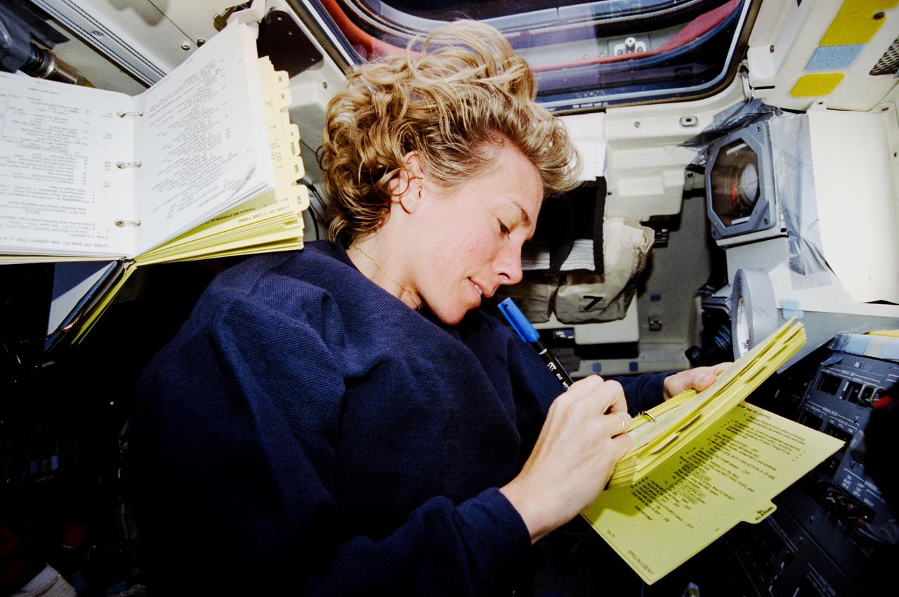 STS083-317-009 (4-8 April 1997) --- Astronaut Susan L. Still, pilot, goes over a checklist at the control panel on the aft flight deck of the Earth-orbiting Space Shuttle Columbia.  Scheduled originally as a 16-day mission, the Microgravity Sciences Laboratory (MSL-1) flight completed about one-fourth of its manifest time frame prior to being cut short by a power shortage.