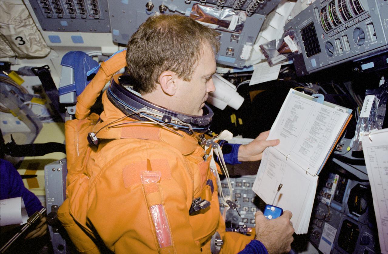 STS083-448-025 (8 April 1997) --- Partially suited in the partial-pressure launch and entry garment, astronaut James D. Halsell, Jr., mission commander, goes over a checklist prior to entry. Halsell, along with four other NASA astronauts and two payload specialists supporting the Microgravity Sciences Laboratory (MSL-1) mission were less than a fourth of the way through a scheduled 16-day flight when a power problem cut short their planned stay.