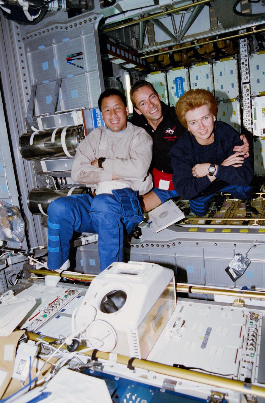 STS084-301-014 (15-24 May 1997) --- Zero-gravity adds a flavor of confusion to this 35mm frame, photographed onboard the Spacehab Double Module during a break in transfer operations of supplies for the STS-84 mission. For orientation purposes, the picture should be held with the glovebox positioned vertically on the right side of the frame. The crew members pictured, from top to bottom, are Elena V. Kondakova, Jean-Francois Clervoy and Edward T. Lu.