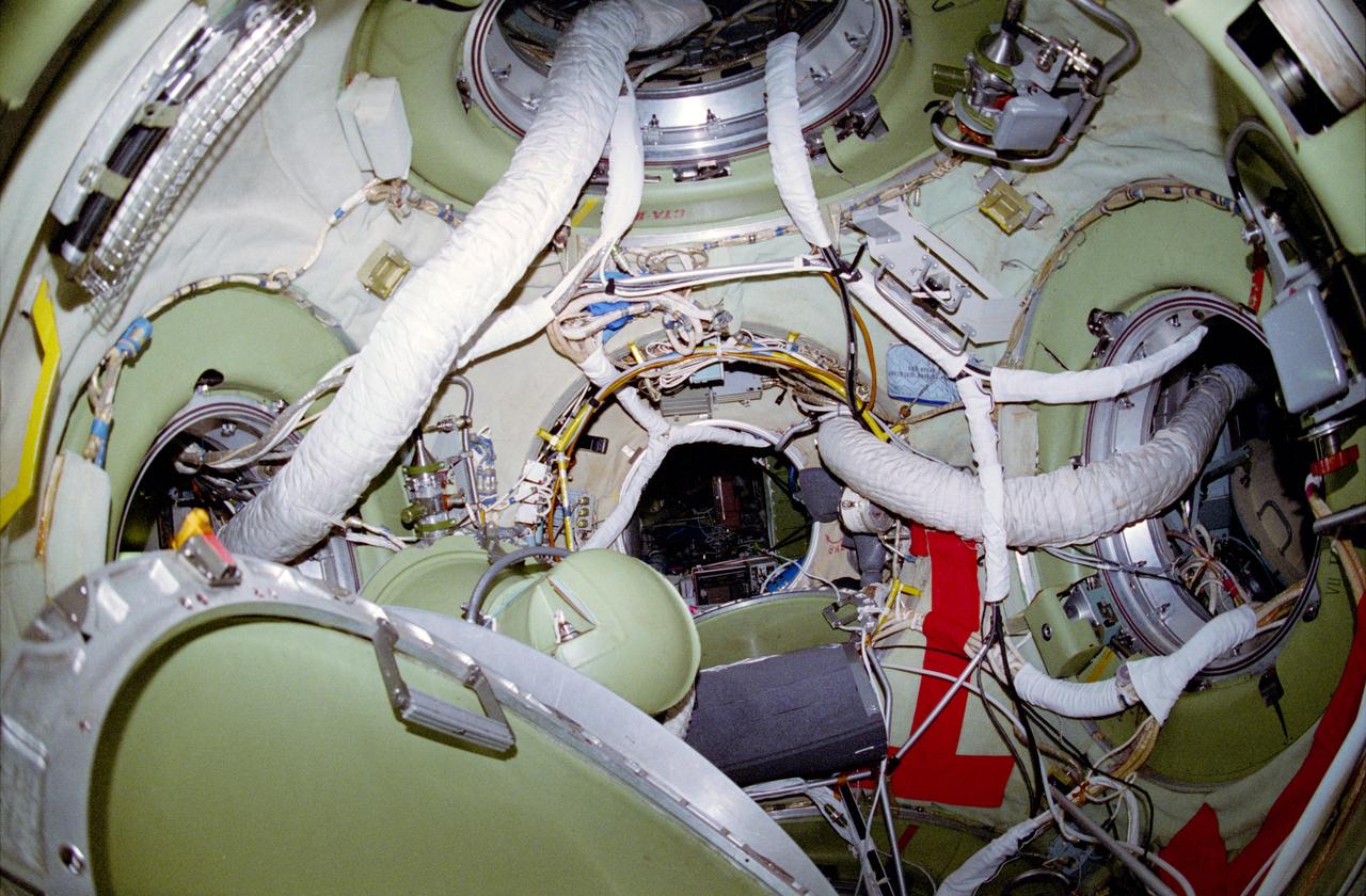 STS084-305-018 (15-24 May 1997) --- As seen from the docked Soyuz hatchway, this 35mm view shows the interior of a Russian Mir Space Station node connected to Kristall (bottom), Priroda (top), Mir Core Module (center), Kvant-2 (left) and Spektr (right). The Mir-23 and STS-84 crew members spent several days sharing joint activities in Earth-orbit as part of an ongoing cooperative program between the Russian Space Agency (RSA) and National Aeronautics and Space Administration (NASA).
