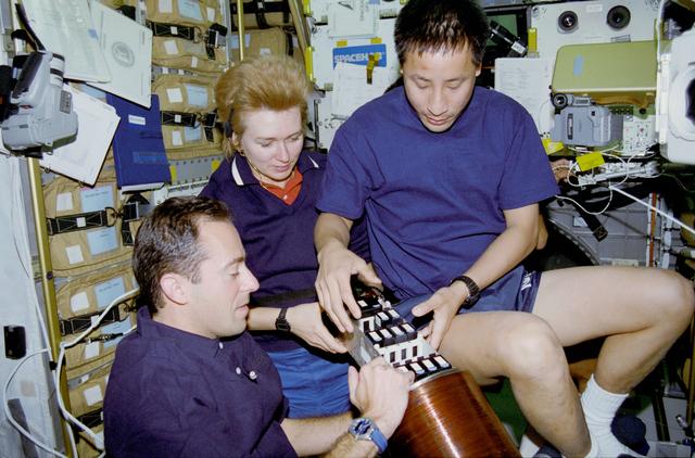 Biorack, Clervoy, Kondakova and Lu put samples in cylindrical container.