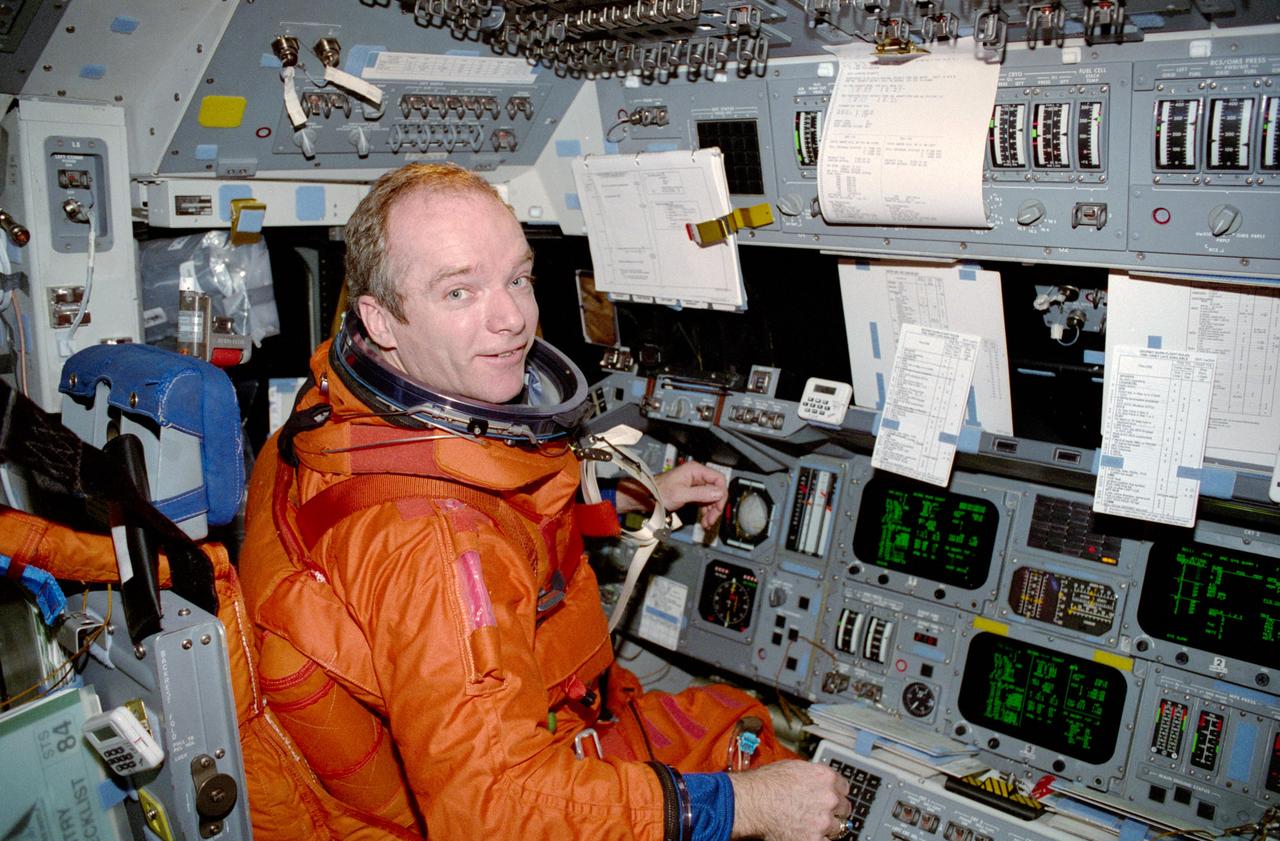 STS084-318-035 (15-24 May 1997) --- Attired in the partial pressure launch and entry garment, astronaut Charles J. Precourt, commander, performs final checkout procedures prior to the re-entry phase of the STS-84 mission. The photo was taken with a 35mm camera by one of the Space Shuttle Atlantis' rear station-seated crewmembers.