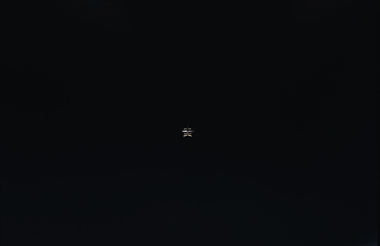 STS084-350-001 (15-24 May 1997) --- Several hundred feet away, Russia's Mir Space Station moves closer and closer to the approaching Space Shuttle Atlantis, as captured on film from the aft flight deck of the space shuttle. Not long after this photo was made, the two spacecraft were docked, a configuration in which they stayed for several days while the two crews conducted joint activities.