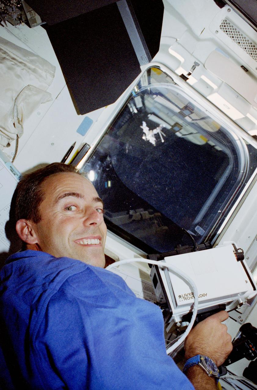 STS084-357-009 (15-24 May 1997) --- Astronaut Jean-Fran?ois Clervoy, STS-84 payload commander, uses a hand held laser range finder during rendezvous operations with Russia's Mir Space Station (seen just above center through the Space Shuttle Atlantis' overhead window).