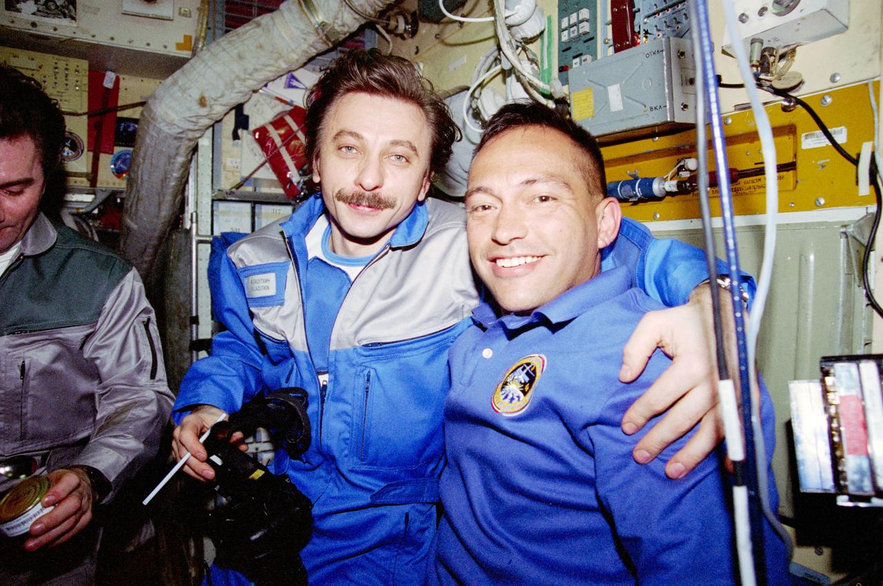 STS084-360-010 (15-24 May 1997) --- On Russia's Mir Space Station's Base Block, Mir-23 flight engineer Aleksandr I. Lazutkin greets his STS-84 counterpart, Carlos I. Noriega, soon after hatch opening.  Partially visible at left is Vasili V. Tsibliyev, Mir-23 commander.