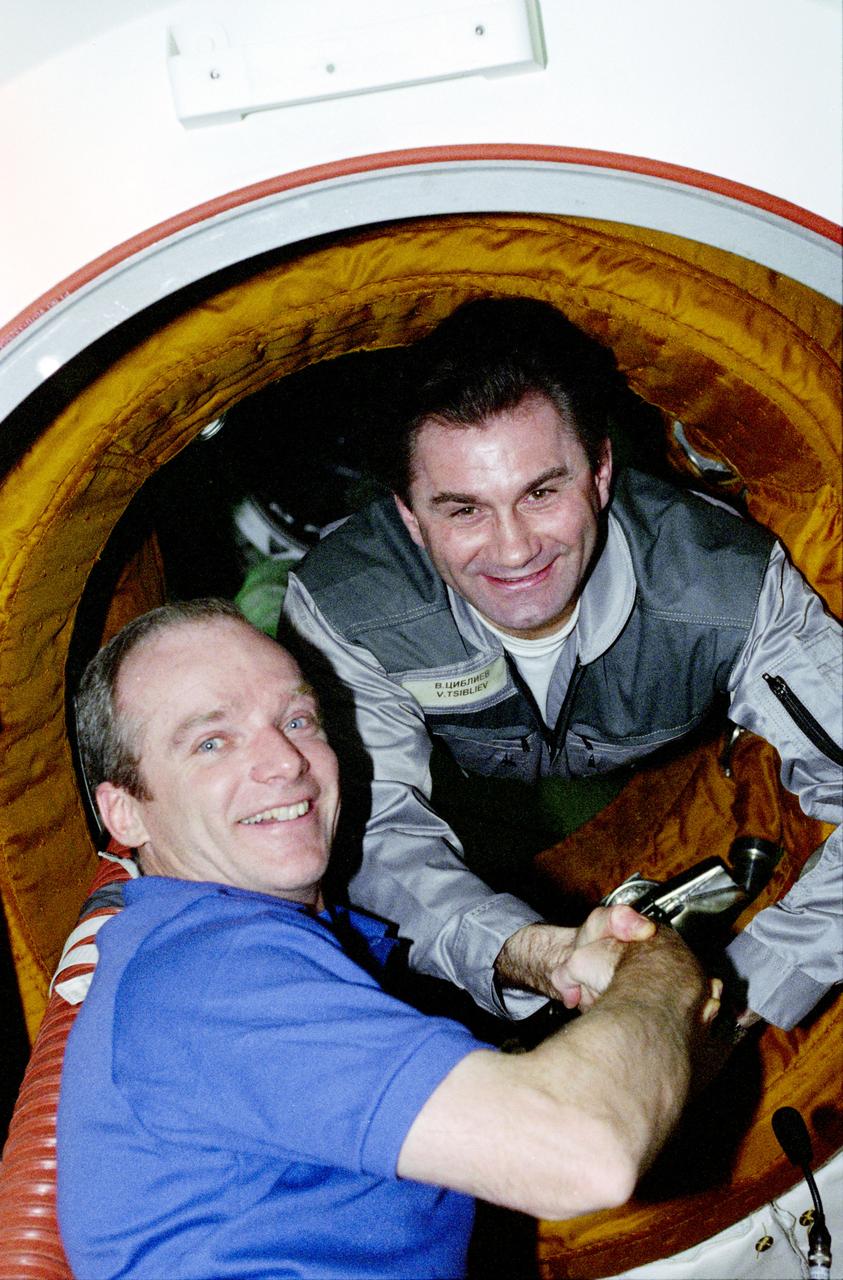 STS084-379-034 (15-24 May 1997) --- Two mission commanders greet and shake hands moments after hatch-opening on docking day, of the Space Shuttle Atlantis and Russia's Mir Space Station. Charles J. Precourt (left), STS-84 commander, and Vasili V. Tsibliyev, Mir-23 commander, along with their respective flight crews went on to spend several days sharing joint activities in Earth-orbit. This is the sixth Atlantis/Mir docking mission.
