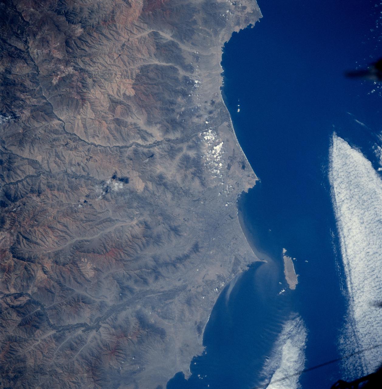 STS084-727-053 (15-24 May 1997) --- This view of Lima, Peru is among a very few photographed by astronauts who have orbited Earth since the early 1960's.  Francisco Pizarro founded the city of Lima in 1535. Lima is located 13 kilometers (8 miles) inland from the Peruvian coast and is surrounded by coastal desert and the Andes mountains. Suburbs of Lima extend in all directions except to the east, where the Andes prohibits growth. The three rivers, Chillion to the northeast of Lima, the Rimac which runs through the northern part of the city, and the Mala to the southeast, all drain the central Andes. The island off the coast is San Lorenzo.