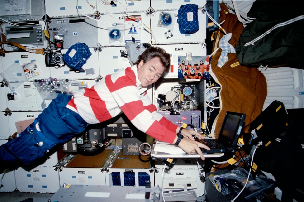 STS085-312-006 (7-19 August 1997) --- Payload specialist Bjarni Tryggvason, representing the Canadian Space Agency (CSA), inputs data into a computer regarding the Microgravity Vibration Isolation Mount (MIM) experiment on the mid-deck of the Space Shuttle Discovery.