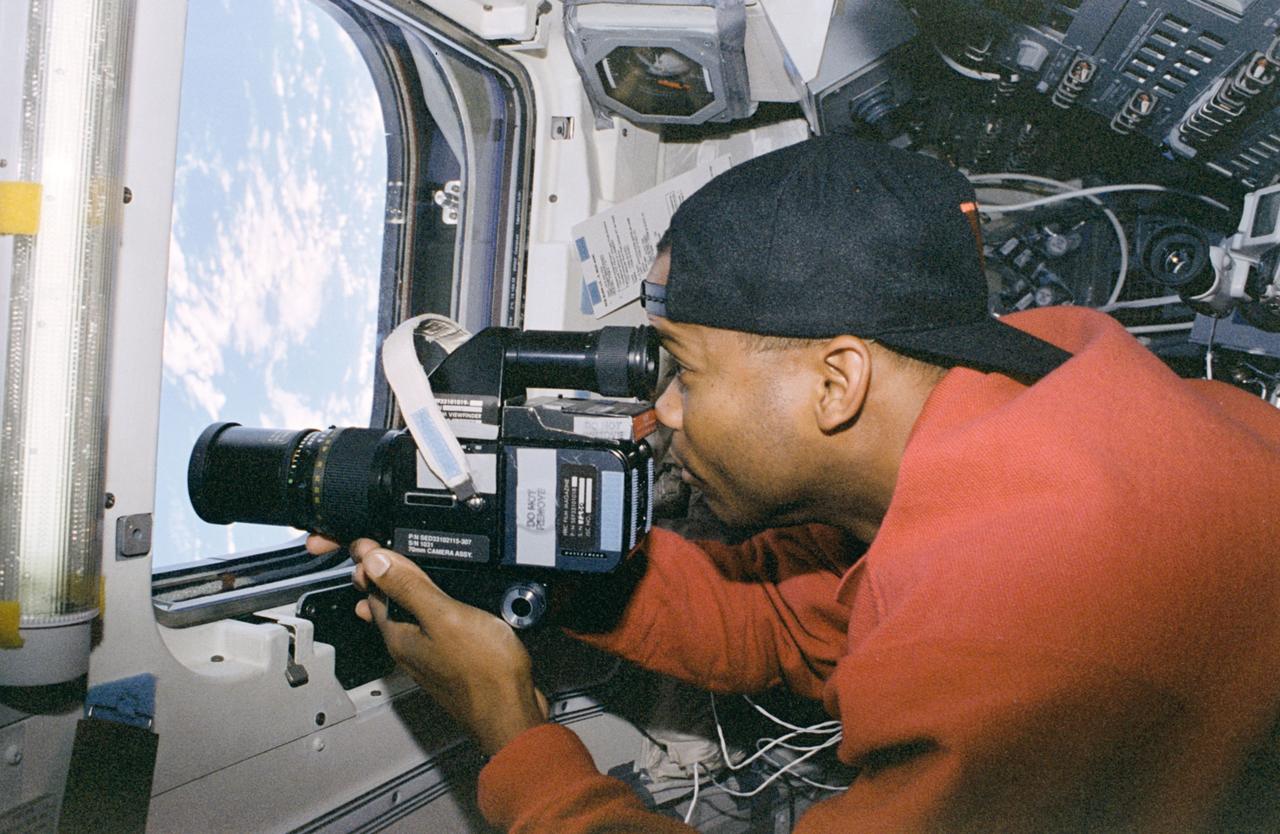 STS085-316-036 (7 - 19 August 1997) --- Astronaut Robert L. Curbeam, Jr., mission specialist, takes pictures of Earth with a 70mm handheld camera through the overhead windows on the aft flight deck of the Space Shuttle Discovery. Curbeam, a member of the 1995 class of astronaut candidates, is making his first flight aboard a Space Shuttle.