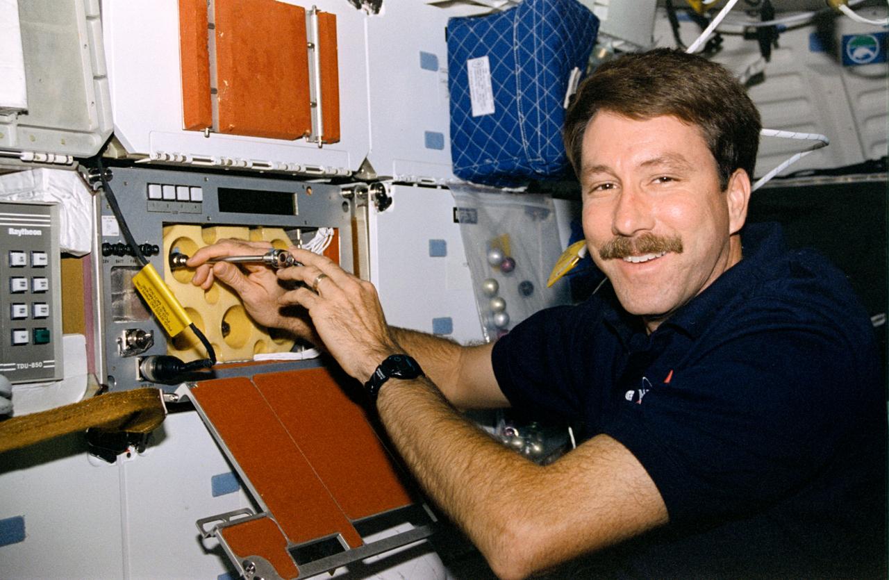STS085-324-007 (7 - 19 August 1997) --- Astronaut Kent V. Rominger, pilot, uses a tool to deactivate the Protein Crystal Growth (PCG) experiment on the mid-deck of the Space Shuttle Discovery near the end of the 12-day STS-85 flight.