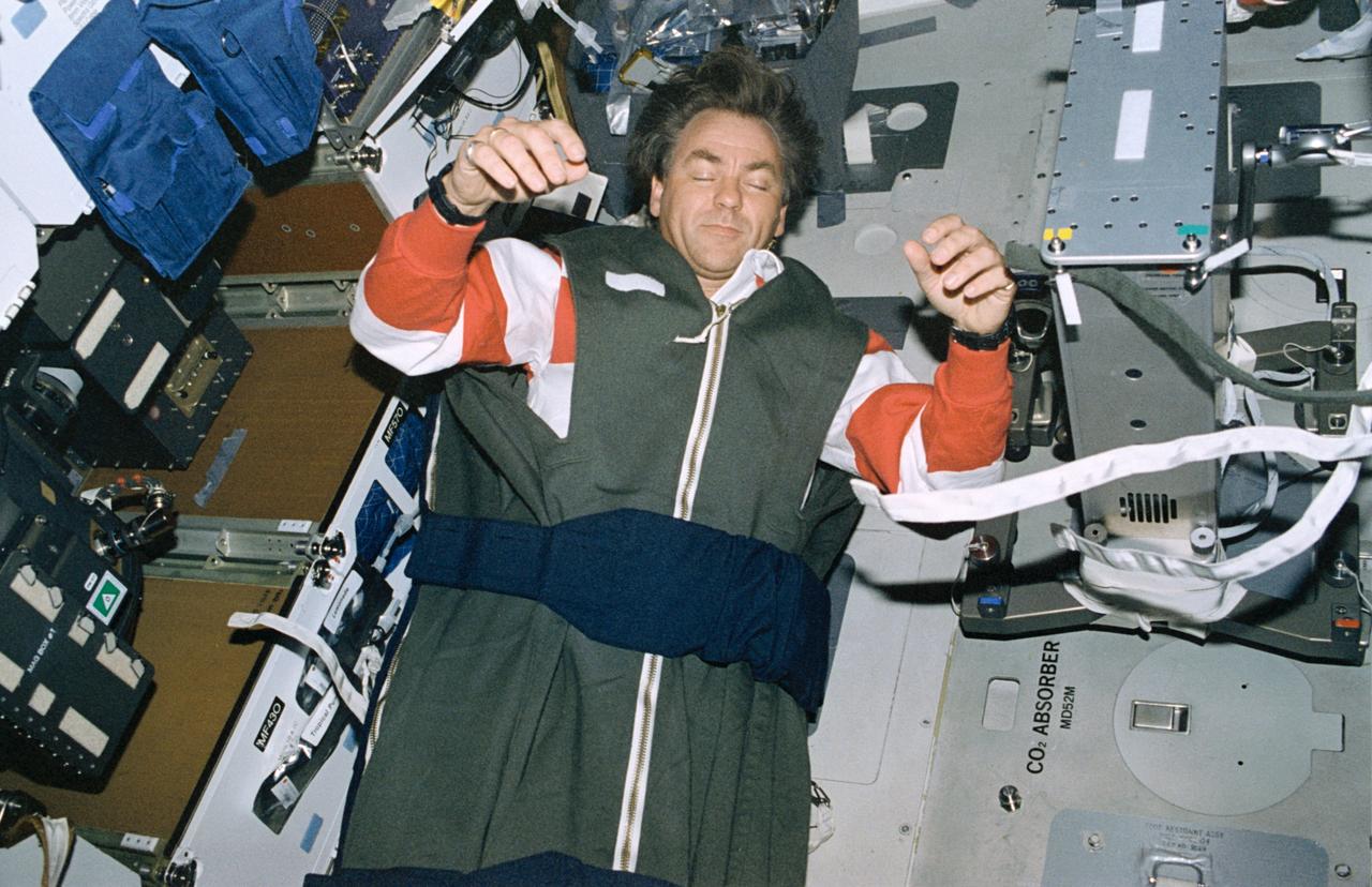 STS085-327-026 (7 - 19 August 1997) --- Payload specialist Bjarni V. Tryggvason, representing the Canadian Space Agency (CSA), sleeps on the Space Shuttle Discovery's mid-deck floor.  Tryggvason elected to not use a pillow, allowing his head to float freely in the Microgravity environment.