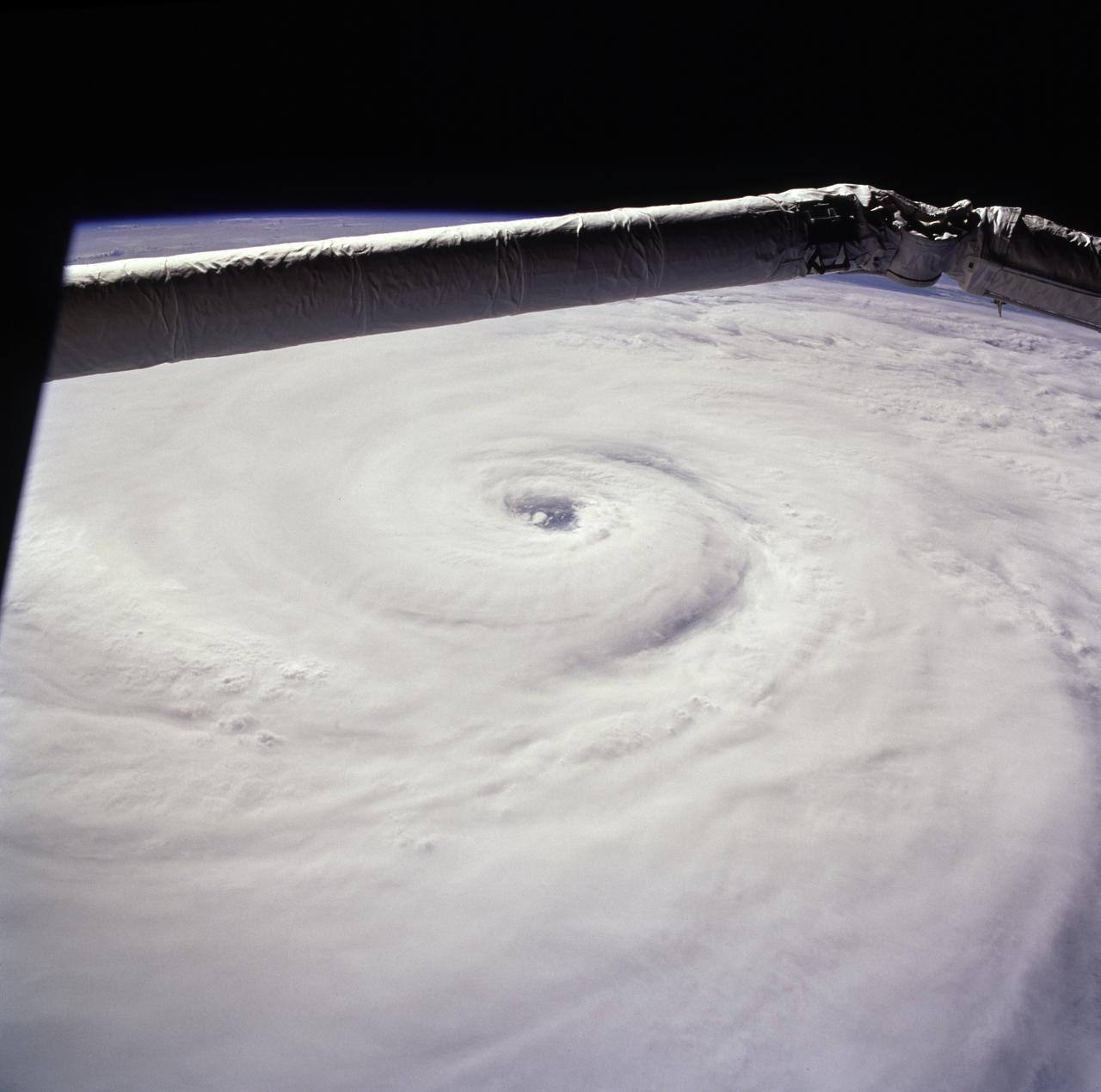 STS085-722-019 (15 August 1997) --- This view of supertyphoon Winnie was taken on August 15, 1997, as the storm swirled about 400 miles south of the southern tip of Japan.  Sustained winds were 105 knots, gusting to 130 knots.  This photo was shot on the Space Shuttle Discovery's twenty-third flight, as it glided by 170 miles above the sea surface on Orbit 123.  On one pass the Discovery flew right over the eye; the commander commented that the eye was so large that it completely filled the window.  The robotic arm crosses the top of the view.  The cloud mass associated with Winnie covered thousands of square miles as this storm grew to supertyphoon status in the previous days, and raked across the Marianas Islands.  A few days after this shot was taken, Winnie ploughed ashore on the coast of China, a bit south of the major metropolis of Shanghai, reportedly killing at least 100 people.