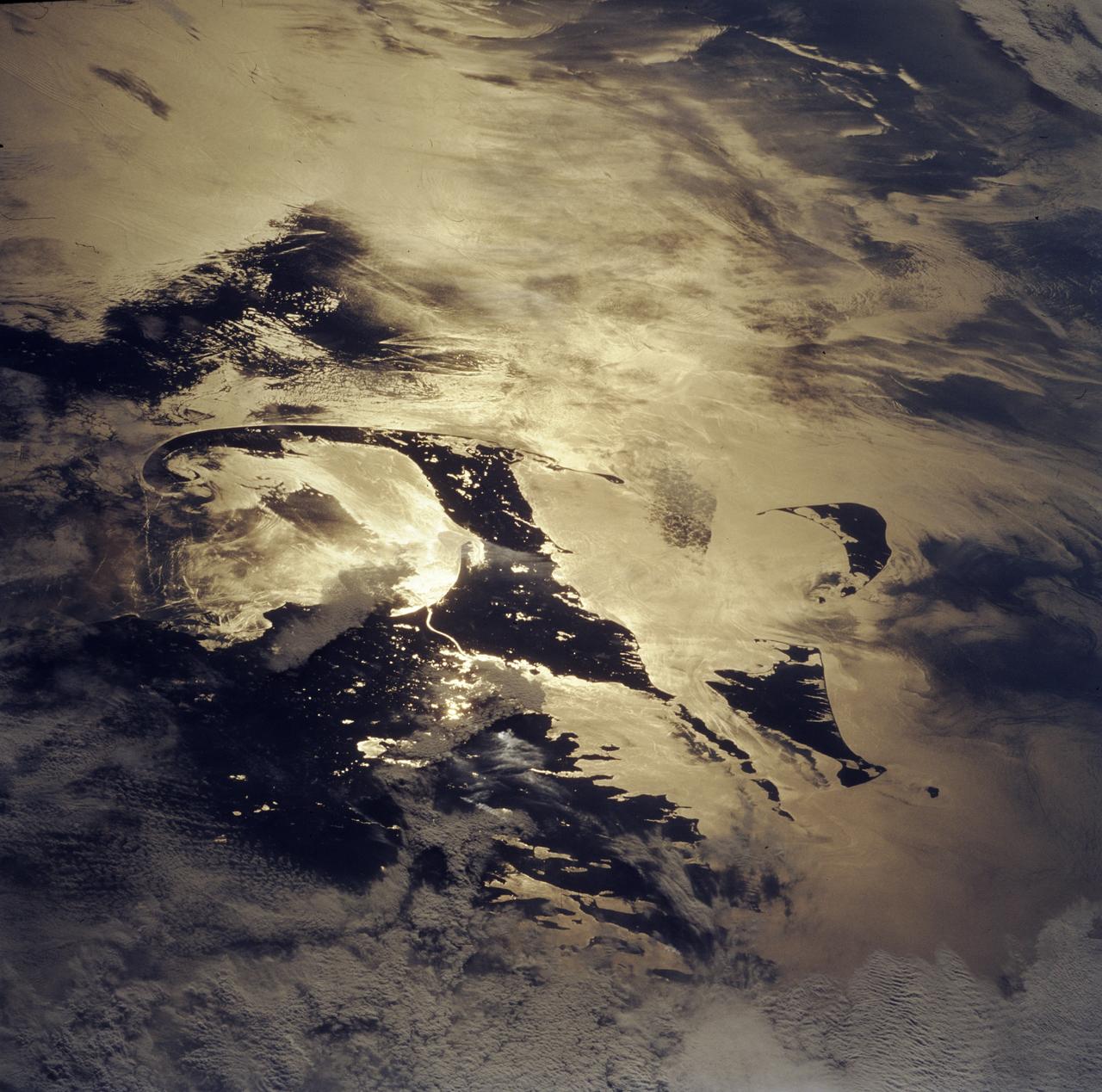 STS085-743-000D (7 - 19 August 1997) --- Cape Cod almost looks like an elf's slipper with this orientation in the sunglint.  The sunglint also reveals other features such as shipwakes, calmer sea surfaces (the darker areas) and internal waves which are waves traveling along a layer of denser water many tens of feet below the surface.