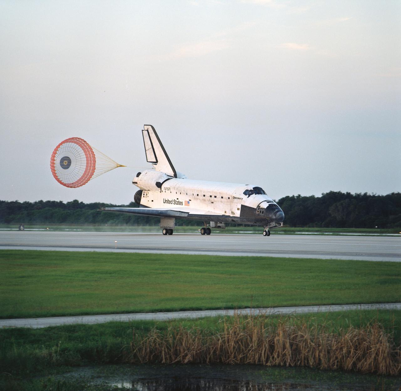 STS085-S-013 (19 August 1997) --- The drag chute of the Space Shuttle Discovery is fully deployed in this scene of the spacecraft's landing on runway 33 at the Kennedy Space Center (KSC). The landing, at 7:08 a.m. (EDT), August 19, 1997, marked the completion of a successful 12-day STS-85 mission. Onboard were astronauts Curtis L. Brown, Jr., mission commander; Kent V. Rominger, pilot; N. Jan Davis, payload commander; and Robert L. Curbeam, Jr., and Stephen K. Robinson, both mission specialists; along with payload specialist Bjarni Tryggvason, representing the Canadian Space Agency (CSA).