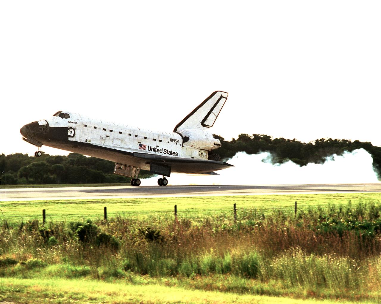 STS086-S-015 (6 Oct 1997) --- The main landing gear of the Space Shuttle Atlantis touches down on the Kennedy Space Center?s (KSC) Shuttle Landing Facility to complete the STS-86 mission.  Touchdown occurred at 5:55:09 p.m. (EDT), October 6, 1997.  Onboard were astronauts James D. Wetherbee, Michael J. Bloomfield, Wendy B. Lawrence, Scott F. Parazynski, Vladimir G. Titov, C. Michael Foale and Jean-Loup J. M. Chretien.  Chretien and Titov represent the French Space Agency (CNES) and the Russian Space Agency (RSA), respectively.