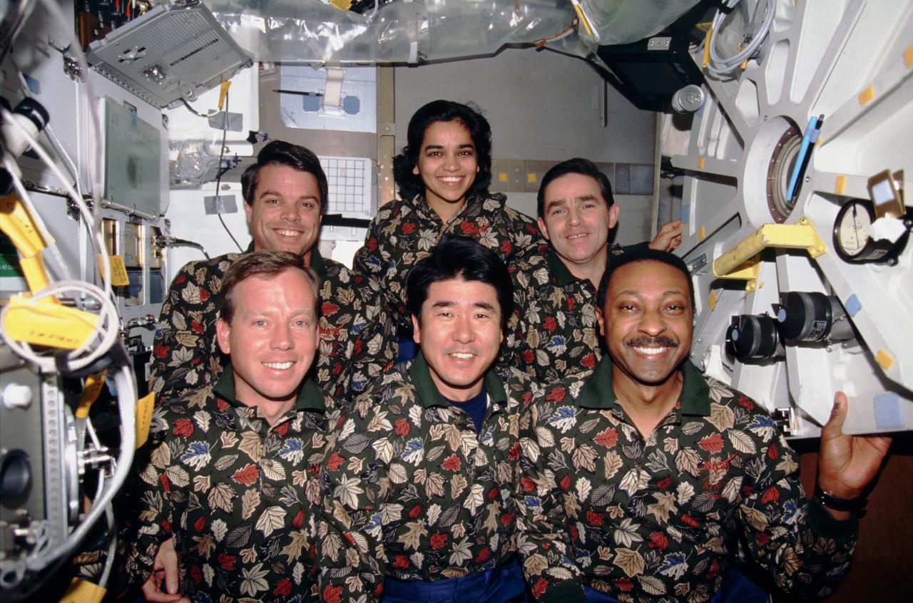 STS087-307-006 (19 November – 5 December 1997) --- One of  the crew members' traditional in-flight crew portraits has them posed in other-than traditional attire on the Space Shuttle Columbia's mid-deck.  On the front row, from the left, are astronauts Steven W. Lindsey, pilot; Takao Doi, an international mission specialist representing Japan's National Space Development Agency (NASDA); and Winston E. Scott, mission specialist.  In the back are astronauts Kevin R. Kregel, mission commander; and Kalpana Chawla, mission specialist, along with Ukrainian payload specialist Leonid K. Kadenyuk.