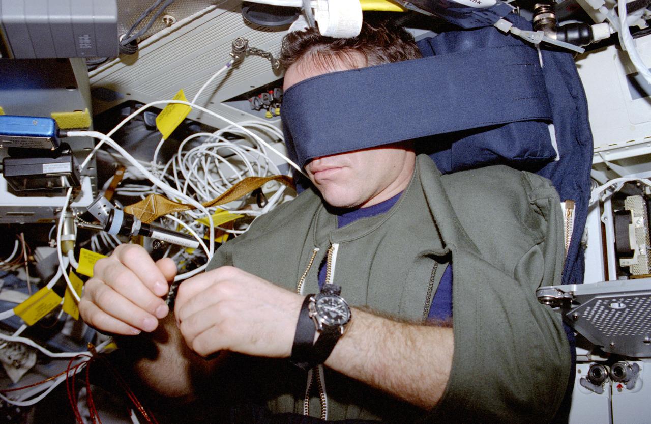 STS087-323-030 (19 November – 5 December 1997) ---  Ukrainian payload specialist Leonid K. Kadenyuk blocks out the world and much more as he sleeps on the mid-deck of the Earth-orbiting Space Shuttle Columbia.  Kadenyuk joined five NASA astronauts for 16 days aboard Columbia in support of the United States Microgravity Payload (USMP) mission.