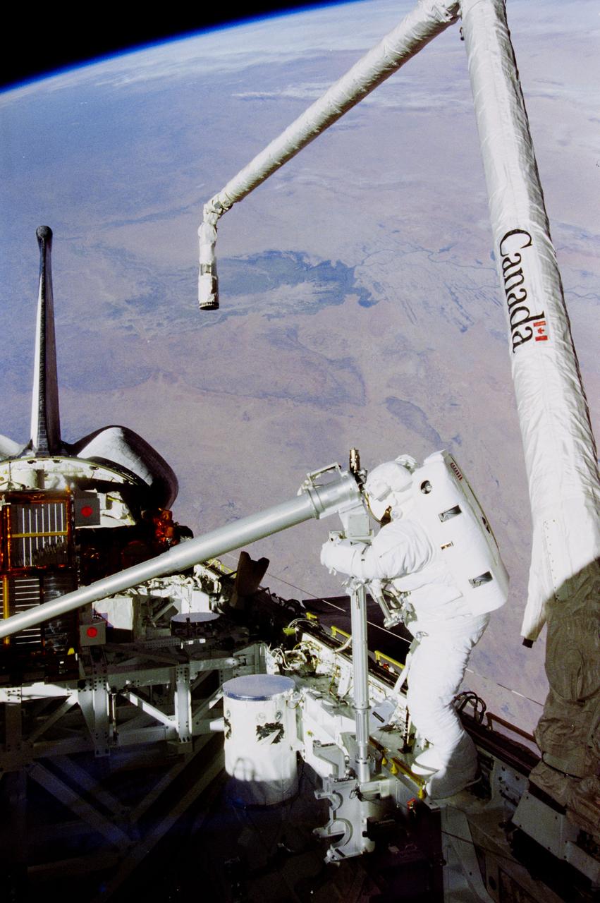 STS087-341-004 (3 Dec. 1997) --- Backdropped over Africa, Takao Doi, international mission specialist representing Japan’s National Space Development Agency (NASDA), works with a crane device during a second extravehicular activity (EVA) designed to help evaluate techniques and hardware to be used in constructing the International Space Station (ISS). Takao Doi and astronaut Winston E. Scott (out of frame) were involved in the mission's second EVA in the cargo bay of the Earth-orbiting Space Shuttle Columbia. Takao Doi is working with a 156-pound crane designed to aid spacewalkers in transporting Orbital Replacement Units (ORU) from translation carts on the exterior of the ISS to various worksites on the truss structure. The view of Earth below features an inland delta in Mali (frame center). This view is from the east toward the west and was taken with a 35mm camera.