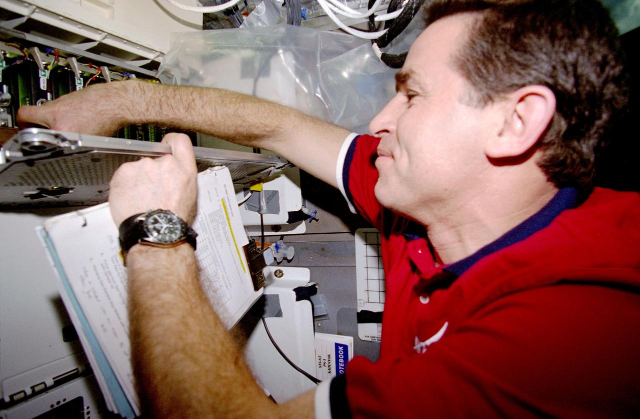 STS087-385-005 (19 November - 5 December 1997) --- Leonid Kadenyuk, Ukrainian payload specialist, retrieves a plant specimen from the plant growth facility on the mid-deck of the Earth-orbiting Space Shuttle Columbia. Kadenyuk and five United States astronauts went on to spend 16-days in Earth-orbit in support of the United States Microgravity Payload (USMP-4) mission.