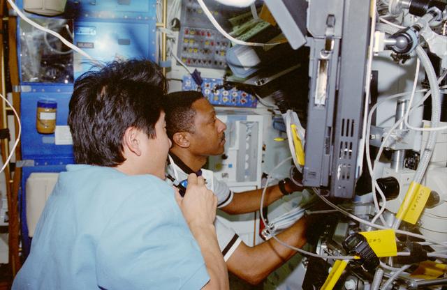 NASA image: USMP-4 MGBX, Scott and Doi work with a glovebox experiment