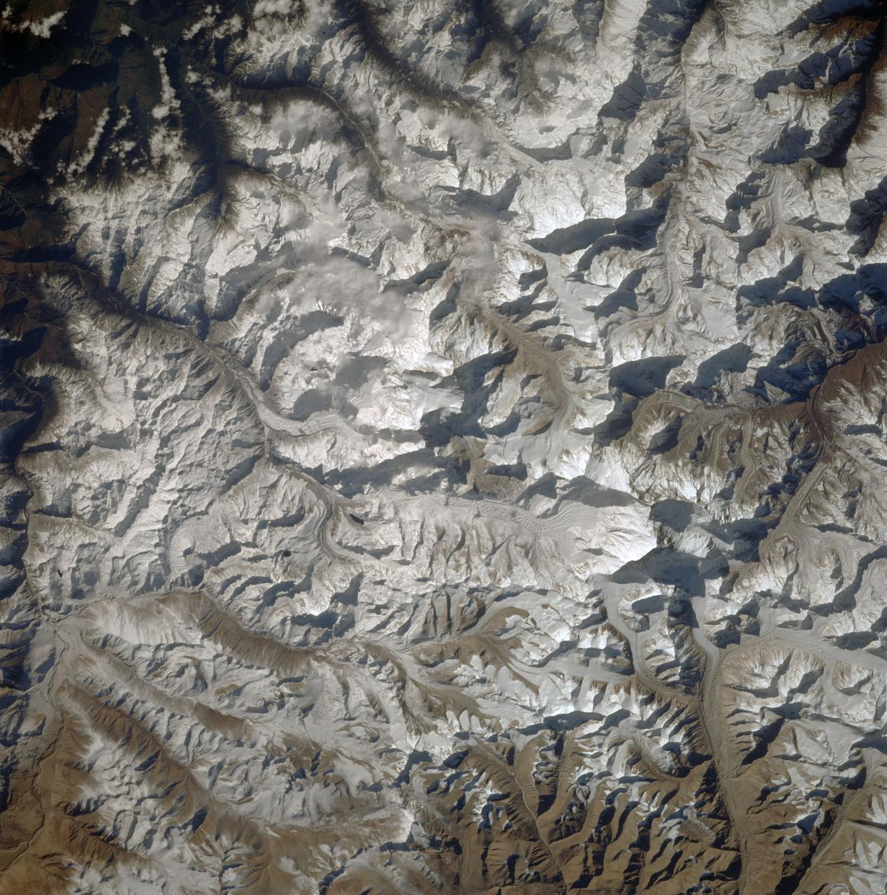 STS087-716-080 (19 November &#0150; 5 December 1997) --- Featured in this view is Mount Everest.  It is called &#0147;Sagarmatha&#0148; in Nepal and &#0147;Qomolangma Feng&#0148; Qomolangma in China (both names meaning &#0147;Goddess Mother of the World&#0148;), but is known to the western world as Mount Everest.  At an altitude of 29,028 feet (8,848 meters) the summit of tallest mountain on Earth (above sea level) reaches two-thirds of the way through the atmosphere.  Situated on the border between Nepal and China (27&#0176;59&#0146;N, 86&#0176;56&#0146;E), Mount Everest with its low oxygen levels, powerful winds, and extremely cold temperatures has captured the imagination of adventuresome men and women.  Sir Edmund Hillary and Tenzing Norgay were the first persons to surmount Mount Everest in 1953. While climbing Everest can be challenging, it can also be tragic.  On May 10, 1996, after reaching the summit and descending to camp, several climbers were trapped by a severe and sudden storm.  A total of eight people died, making this day the deadliest single tragedy in the history of Mount Everest.  This picture is one of the 70mm Earth observations visuals used by the crew at its post flight presentation events.