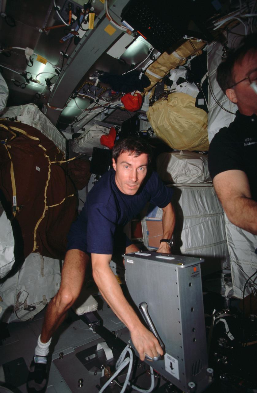 STS088-307-036 (4-15 December 1998) --- Cosmonaut Sergei K. Krikalev, mission specialist, uses a bicycle ergometer to exercise his upper body on the busy middeck of the Earth-orbiting Space Shuttle Endeavour.  Krikalev, named recently to serve on the first International Space Station (ISS) crew, is representing the Russian Space Agency (RSA).  After devoting the major portion of its mission time to various tasks to ready the Russian-built FGB Module (Zarya) and the docked United States-built Unity Module (Node 1), the six-member crew released the tandem toward mission’s end.