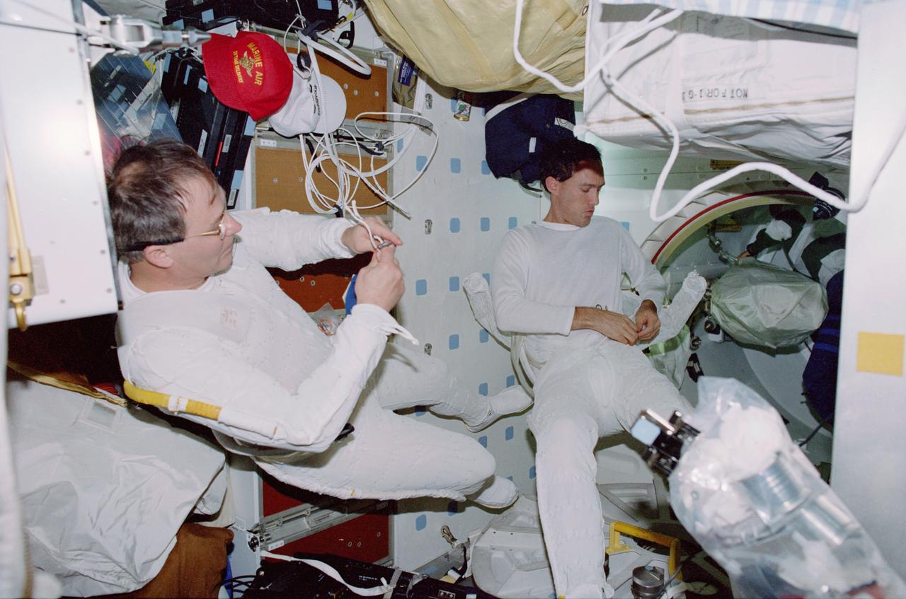 STS088-319-031 (4-15 December 1998) --- Astronauts Jerry L. Ross (left) and James H. Newman, both mission specialists, are pictured in their thermal undergarments prior to the first extravehicular activity (EVA) for the mission.  They went on to complete a total of three such spacewalks designed to help prepare the recently-connected Russian-built FGB Module (Zarya) and the United States-built Unity Module (Node 1), the first two modules for the International Space Station (ISS).