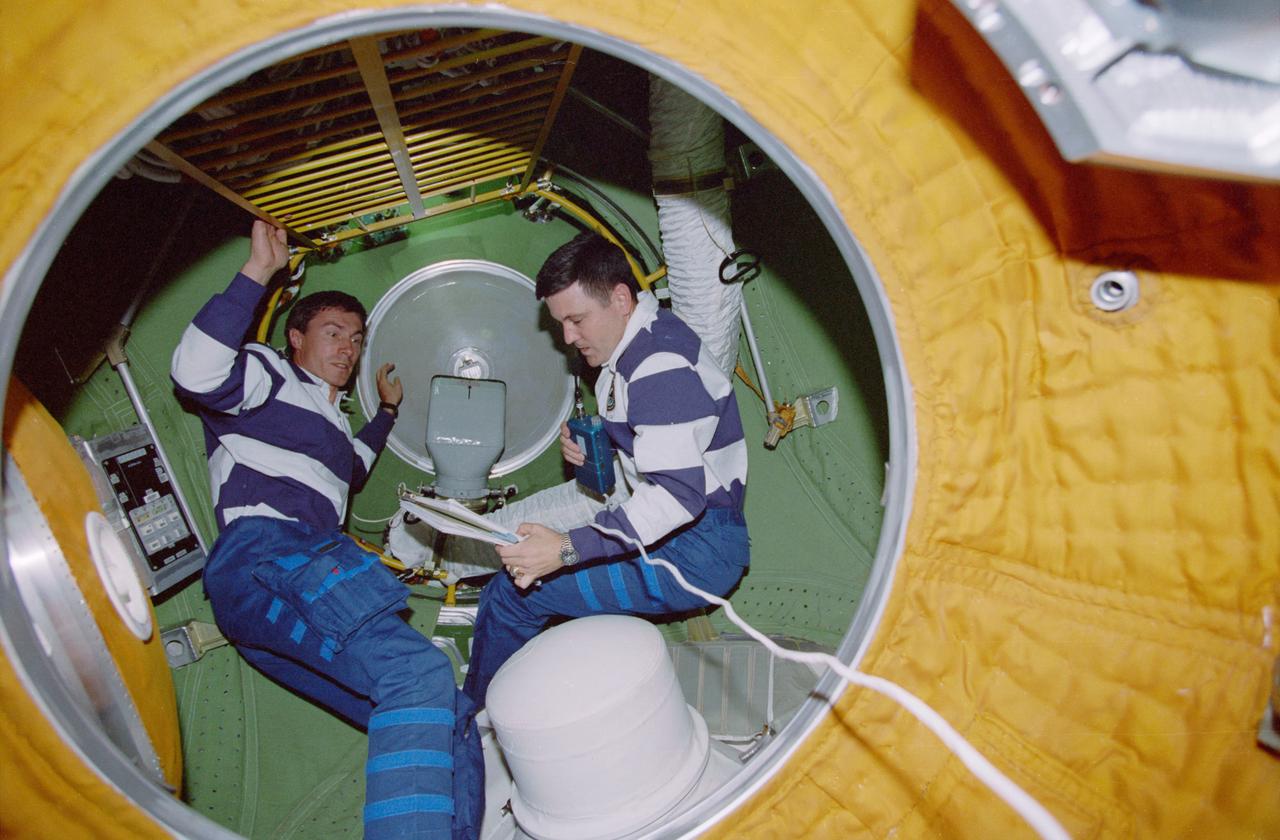 STS088-332-010 (4-15 Dec. 1998) --- Cosmonaut Sergei K. Krikalev (left), mission specialist representing the Russian Space Agency (RSA),  and astronaut Robert D. Cabana  mission commander, plan their approach to tasks as they huddle at an internal hatch in the Russian built FGB, also called Zarya.   All six STS-88 crew members were involved in tasks to ready  Zarya and the now-connected U.S. Node 1, also called Unity, for their International Space Station (ISS) roles.  Krikalev has been named as a member of the first ISS crew.