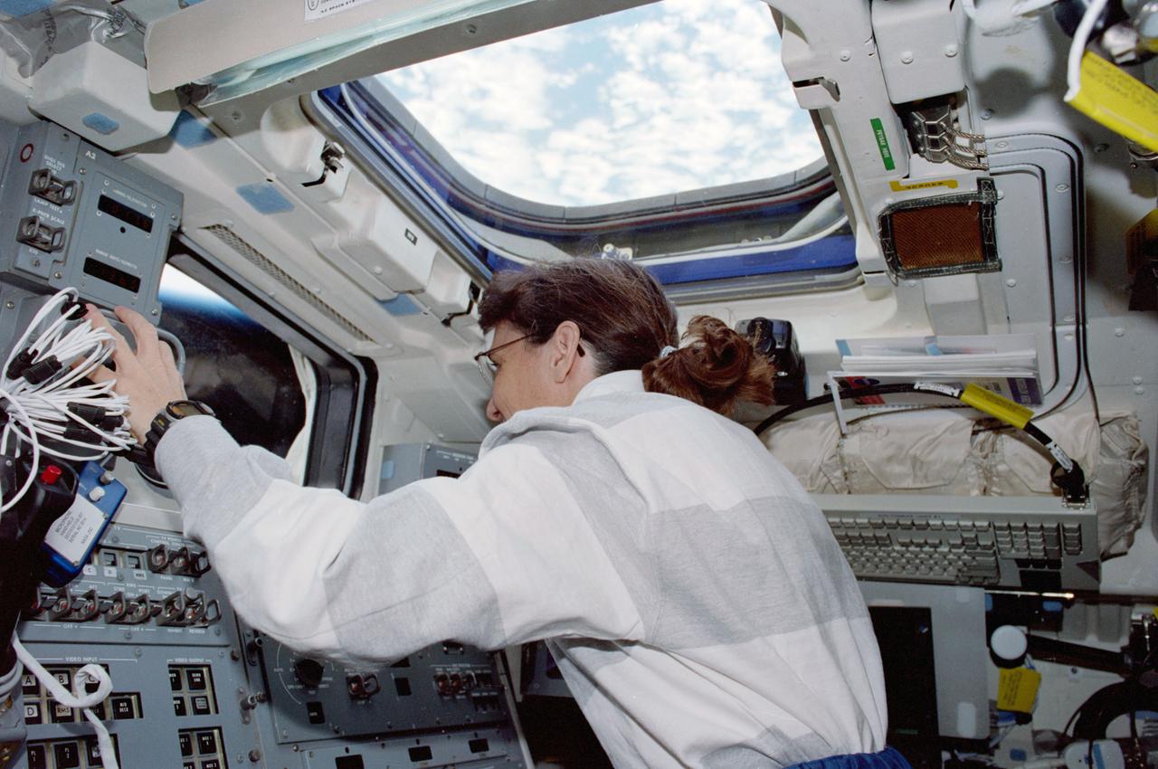 STS088-335-006 (4-15 Dec. 1998) --- Astronaut Nancy J. Currie, mission specialist, looking out the aft flight window, works the controls of the Remote Manipulator System (RMS) arm onboard the Earth-orbiting Space Shuttle Endeavour. She was in the process of moving the stowed United States-built Unity Module (Node 1) into a docked configuration with Endeavour?s docking system. This process preceded rendezvous and docking with the Russian-built FGB Module (Zarya).