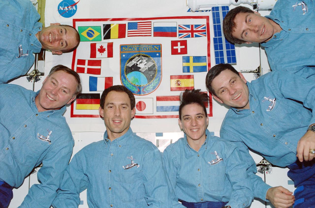 STS088-350-010 (4-15 Dec. 1998) --- STS-88 in-flight crew portrait taken on the Endeavour's middeck with a  banner in the background which depicts the flags of all the international  partners. From left to right are: Frederick W. "Rick" Sturckow, pilot; Jerry L. Ross, James H. Newman and Nancy J.  Currie, all mission specialists; Robert D. Cabana, mission commander; and  Sergei K. Krikalev, mission specialist, representing the Russian Aviaiton and Space Agency (Rosaviakosmos).