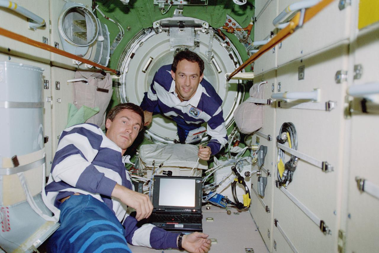 STS088-357-008 (4-15 Dec. 1998) --- Cosmonaut Sergei K. Krikalev (foreground), mission specialist representing the Russian Space Agency (RSA), and astronaut James H. Newman, mission specialist, participate in video teleconference with ground controllers while working in the Russian-built FGB or Zarya Module.  At the time the photo was made, Zarya was docked with the United States-built Unity (Node 1) Module, which was temporarily connected to the Space Shuttle Endeavour?s cargo bay.  The mission specialists, along with other members of the crew, were in the process of setting up interior systems of Zarya.